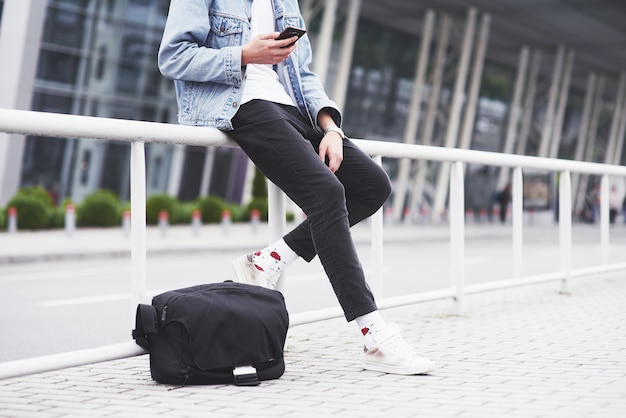 Photo gratuite un jeune homme attend un passager à l'aéroport.