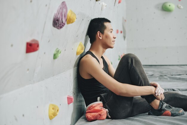 Jeune homme au repos dans l'escalade