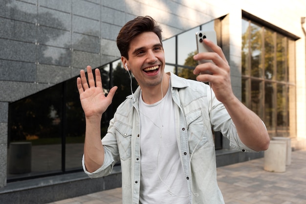 Photo gratuite jeune homme ayant un appel vidéo sur son smartphone