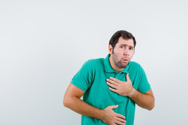 Jeune homme ayant un estomac sur fond blanc