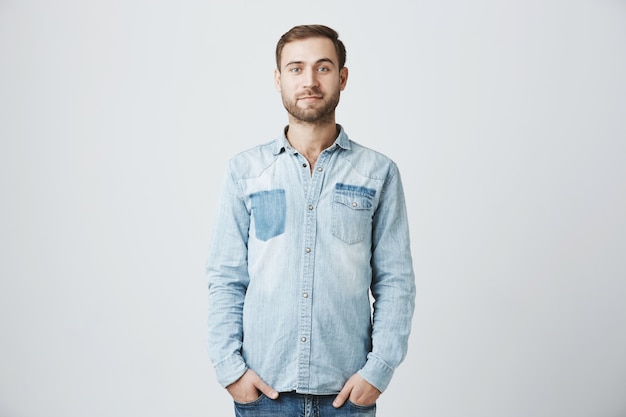 Jeune homme barbu caucasien avec les mains dans les poches