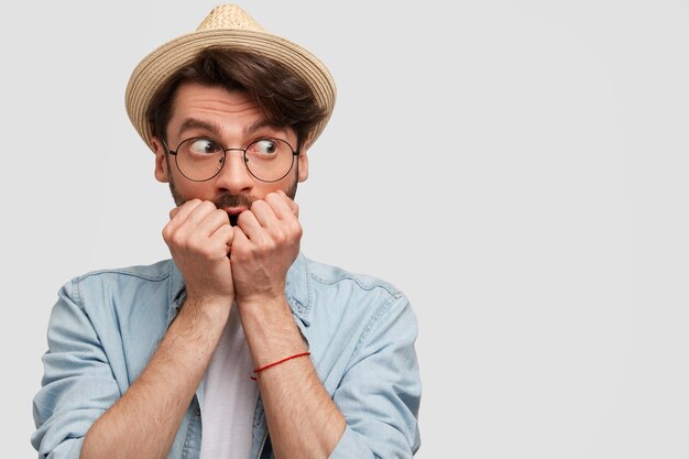 Jeune homme barbu avec des lunettes rondes et une chemise en jean