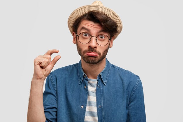 Jeune homme barbu avec des lunettes rondes et une chemise en jean