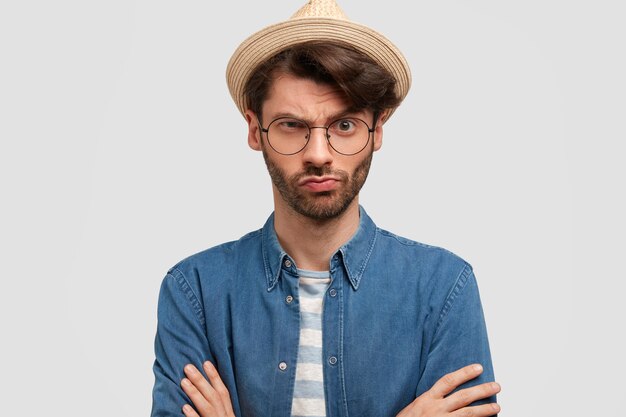 Jeune homme barbu avec des lunettes rondes et une chemise en jean