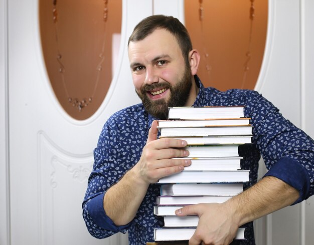 Un jeune homme barbu avec des manuels pour l'étude