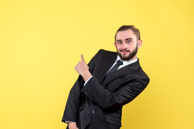 Jeune homme barbu pointant quelque chose sur jaune