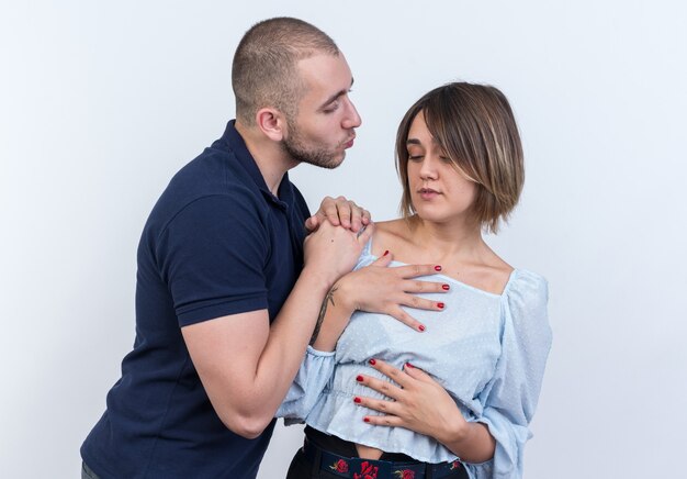 Jeune homme beau couple demandant pardon à sa petite amie pleine de ressentiment debout