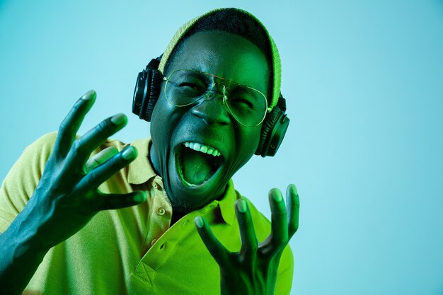 Le jeune homme beau hipster écoute de la musique avec des écouteurs