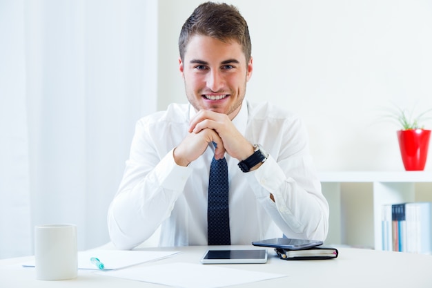 Photo gratuite jeune homme beau travaillant dans son bureau.