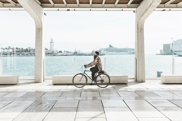 Jeune homme à bicyclette près du port