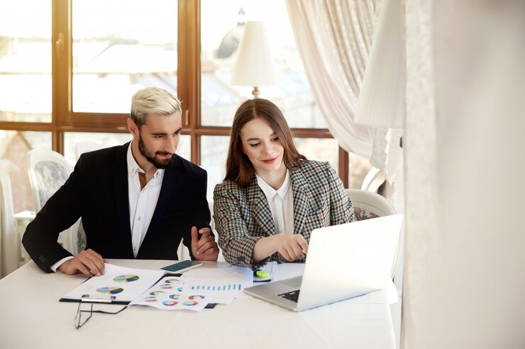 Photo gratuit jeune homme blond et femme brune regardent l'ordinateur et discutent des plans d'affaires
