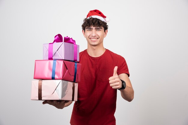 Jeune homme en bonnet de Noel abandonnant les pouces vers le haut.