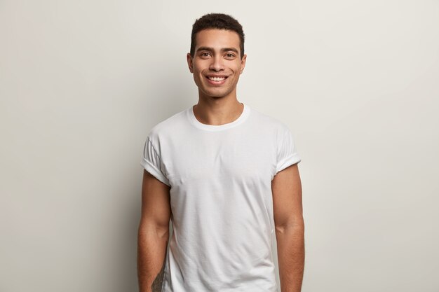 Jeune homme brun portant un t-shirt blanc