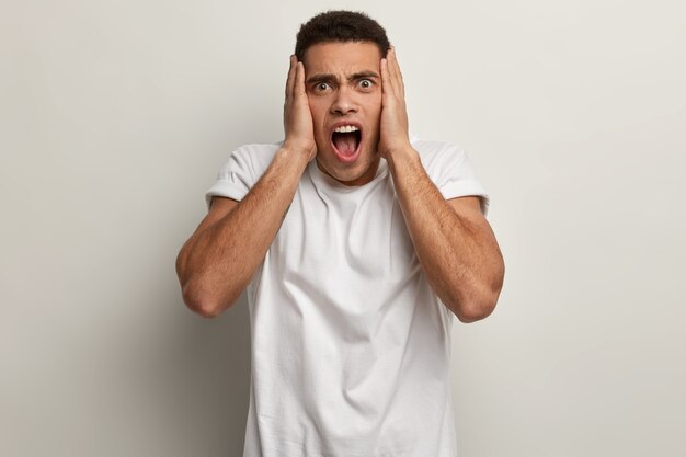 Jeune homme brun portant un t-shirt blanc