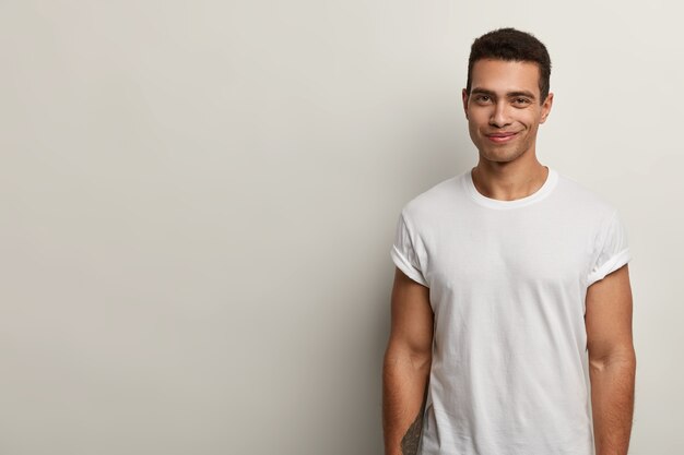 Jeune homme brun portant un t-shirt blanc