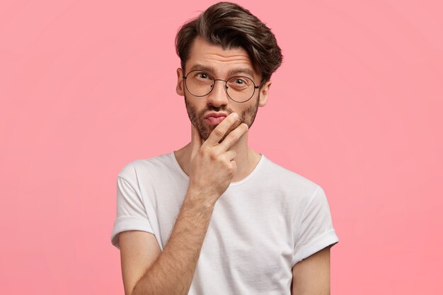 Jeune homme brunet portant des lunettes à la mode