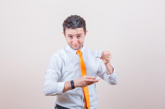 Jeune homme buvant du café turc en chemise blanche, cravate et à la gaieté