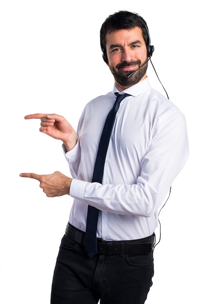 Photo gratuite jeune homme avec un casque pointant vers le côté