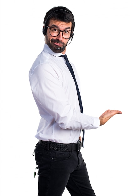 Jeune homme avec un casque présentant quelque chose