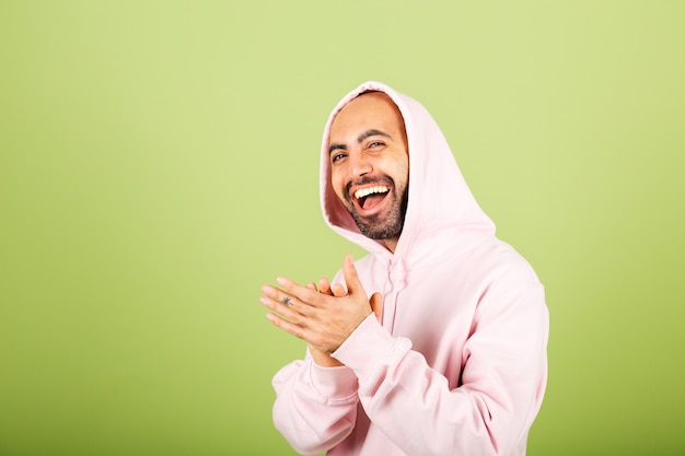 Jeune homme caucasien chauve en sweat à capuche rose isolé, heureux applaudissant et applaudissant heureux et joyeux, souriant mains fières ensemble