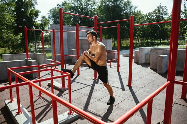 Jeune homme caucasien torse nu musclé faisant des exercices d'étirement