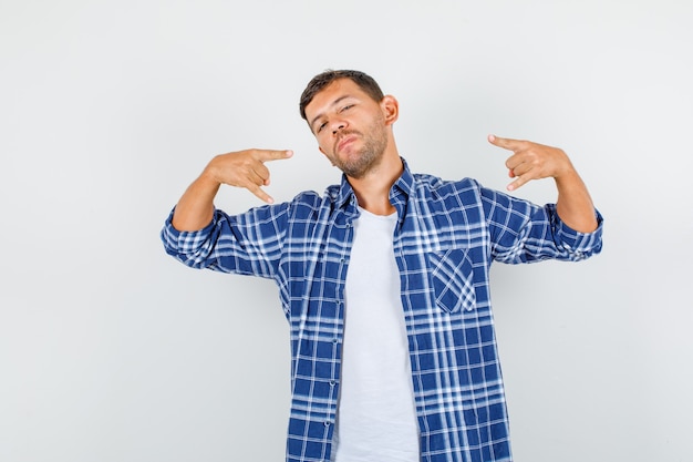 Jeune homme en chemise faisant le geste de la main rock et à la vue de face, confiant.