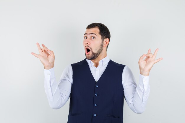 Jeune homme en chemise, gilet faisant la méditation et à l'agitation