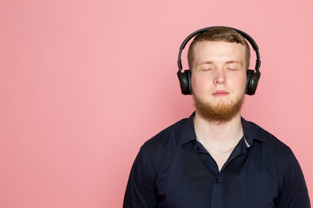 Photo gratuite jeune homme en chemise noire avec un casque noir