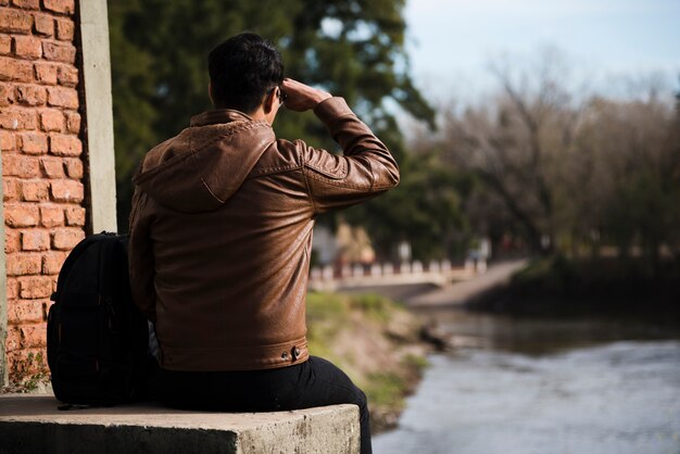 Jeune homme cherche loin à l'extérieur