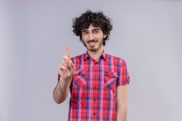 Jeune homme cheveux bouclés isolé chemise colorée un doigt