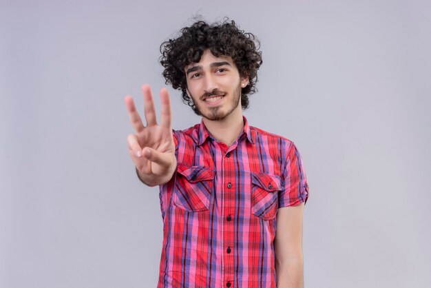 Jeune homme cheveux bouclés isolé chemise colorée trois doigts