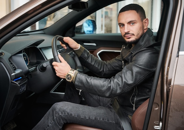 Jeune homme conduisant une voiture moderne