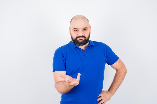 Jeune homme confiant en t-shirt bleu