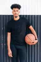 Photo gratuite jeune homme cool, debout, contre, mur, tenue, basket-ball