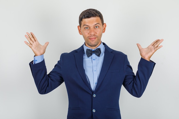 Jeune homme en costume ouvrant largement les mains et à la recherche de plaisir