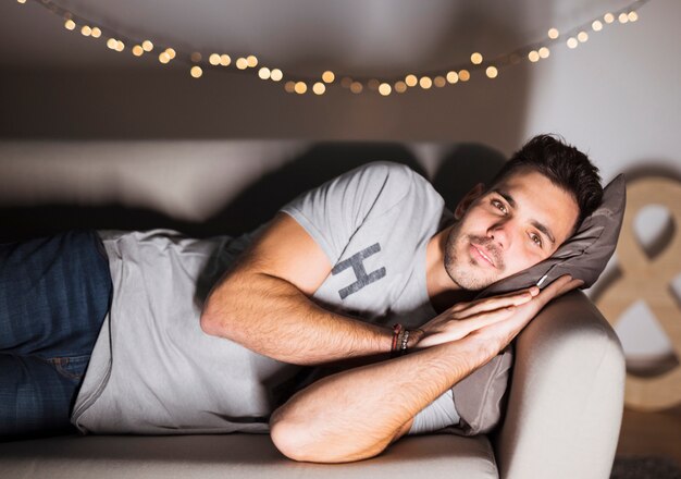 Jeune homme, coucher divan, et, regarder télé