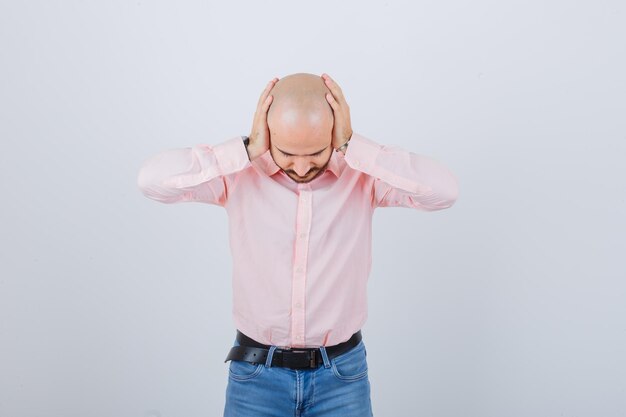 Jeune homme couvrant les oreilles avec les mains