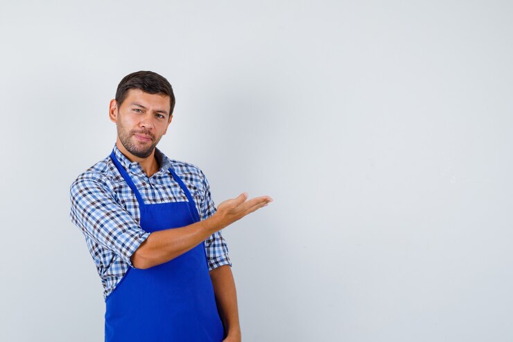 Photo gratuit jeune homme cuisinier dans un tablier bleu et une chemise