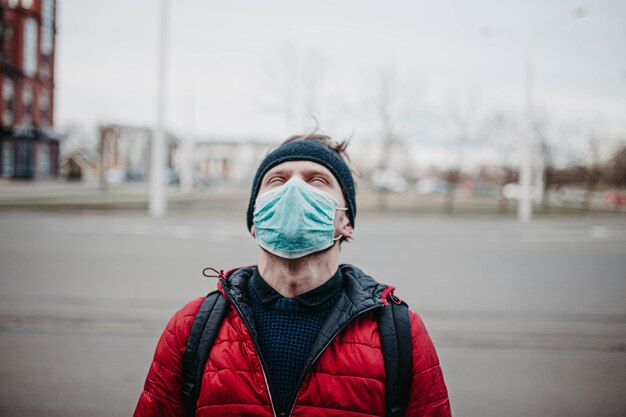 Jeune homme dans un masque médical dans une ville pendant une pandémie