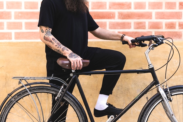 Photo gratuite jeune homme, debout, bicyclette, contre, mur