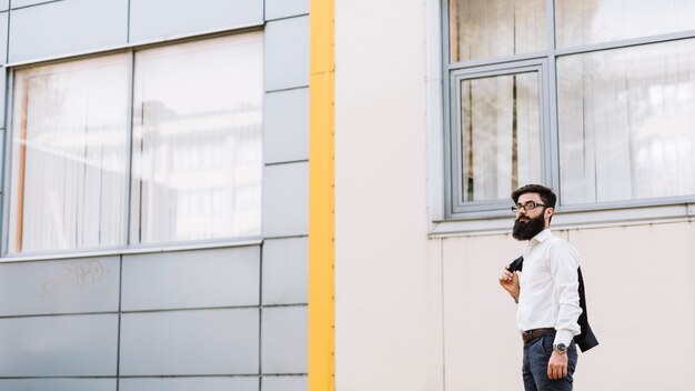 Jeune homme debout près du bâtiment corporatif