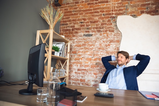 Un jeune homme, directeur, équipe dirigée par le retour au travail dans son bureau après la quarantaine, se sent heureux et inspiré