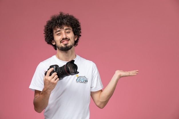 jeune homme donnant la main vide avec sa photocamera