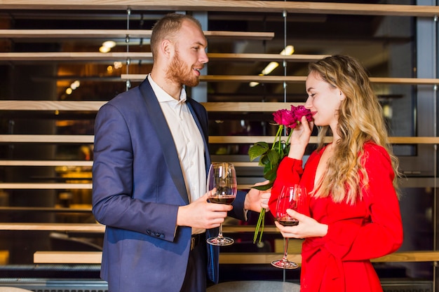 Photo gratuite jeune homme, donner, roses, bouquet, à, femme, à, verre vin