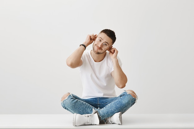 Jeune homme drôle et mignon avec des lunettes posant