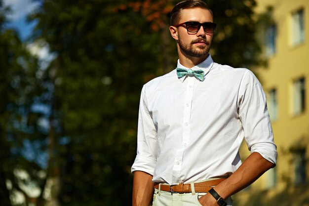 Jeune homme élégant beau modèle sexy dans un style de vie en tissu décontracté dans la rue dans des verres