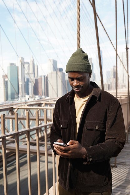 Photo gratuite jeune homme élégant explorant un pont de la ville par lui-même