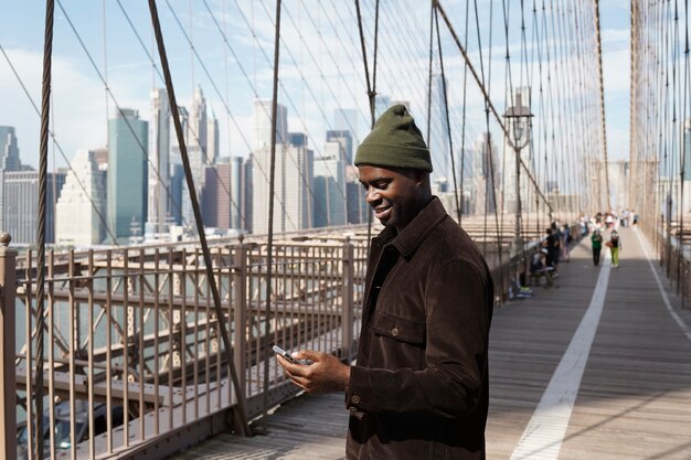 Jeune homme élégant explorant un pont de la ville par lui-même