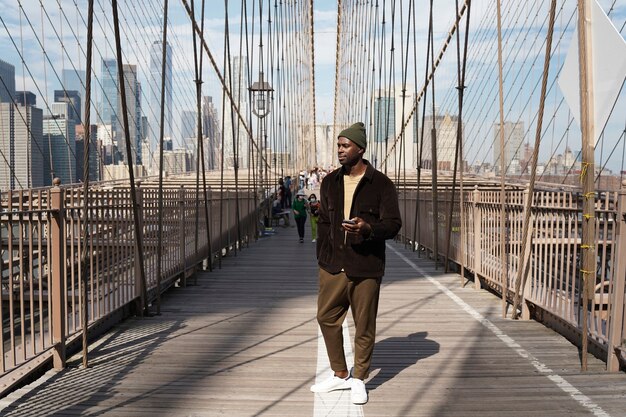 Jeune homme élégant explorant un pont de la ville par lui-même