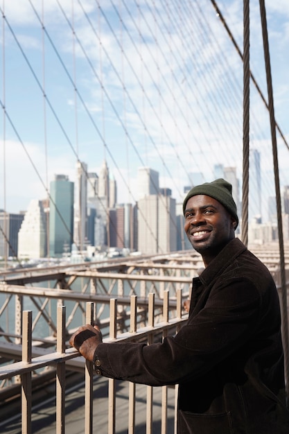 Photo gratuite jeune homme élégant explorant un pont de la ville par lui-même